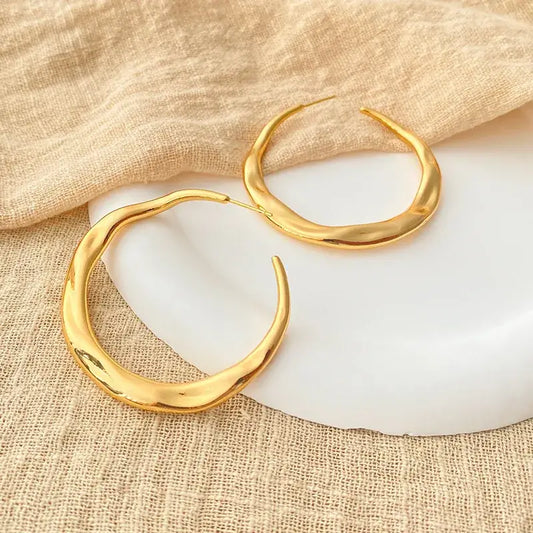 Close-up of irregular copper stud earrings showing unique irregular shape