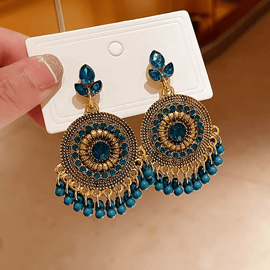 Retro ethnic tassel earrings with geometric design and blue accents on a display card.