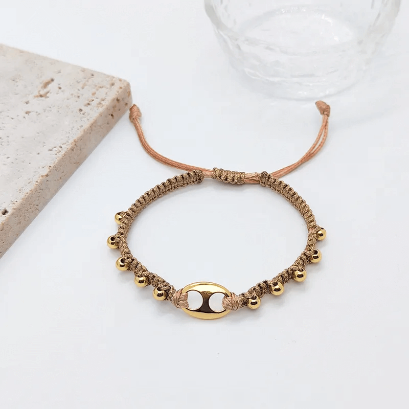 18K gold plated charm bracelet featuring delicate gold bells on a woven cord.