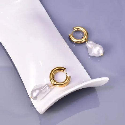 Close-up of irregular gold-plated earrings showing delicate artificial pearls