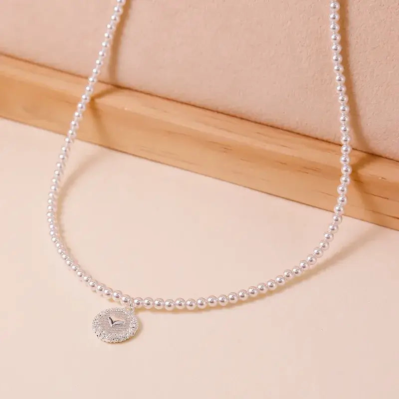 Freshwater pearl pendant necklace worn by model with layered jewelry