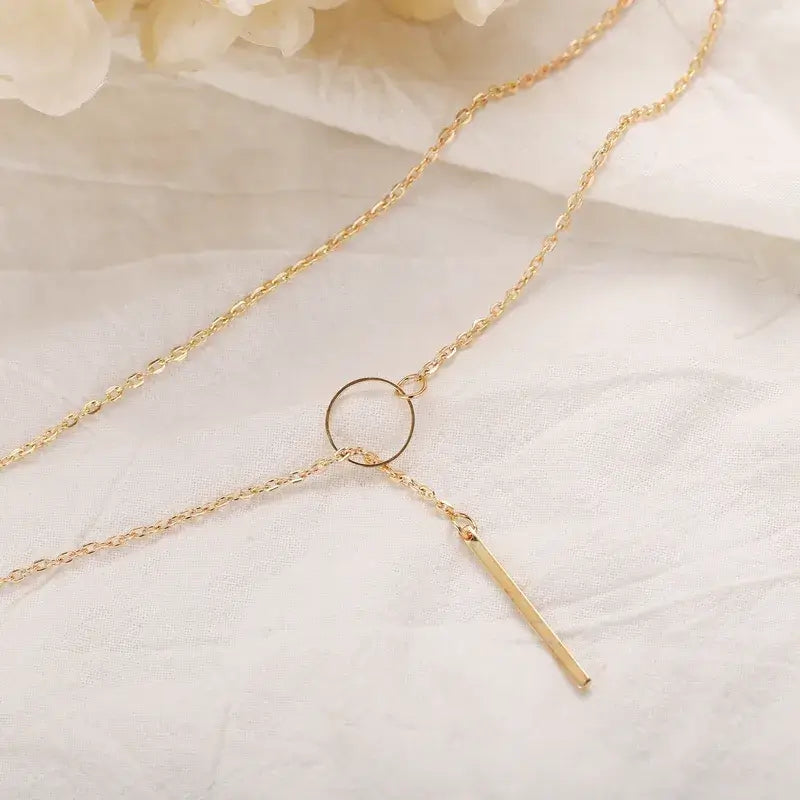 Minimalist Y-shaped necklace worn by model with layered jewelry