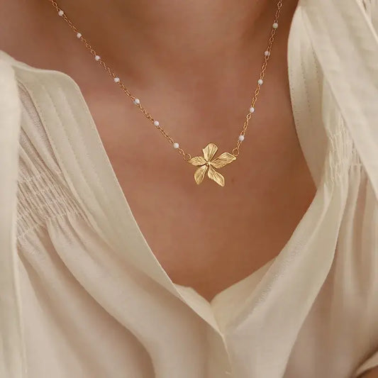 Close-up of gold-plated flower pendant necklace showing detailed flower pendant