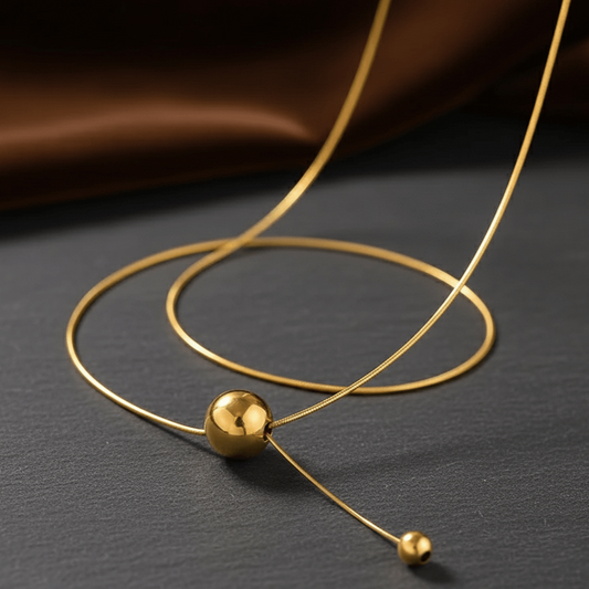 18K gold plated pendant necklace – Stainless Steel featuring a minimalist design with a smooth gold ball centerpiece.
