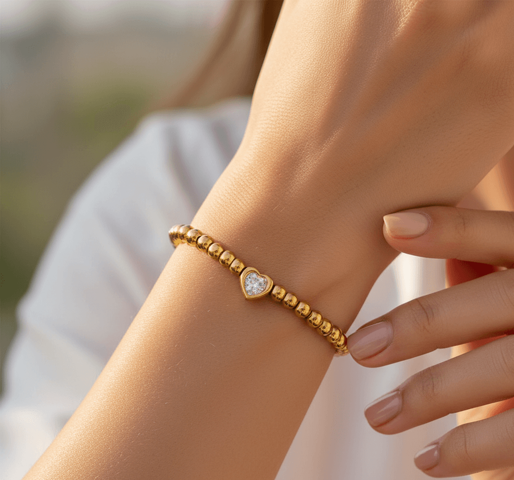 16K gold plated heart bracelet worn on a woman's wrist, showcasing elegant design and sparkling zircon inlay.