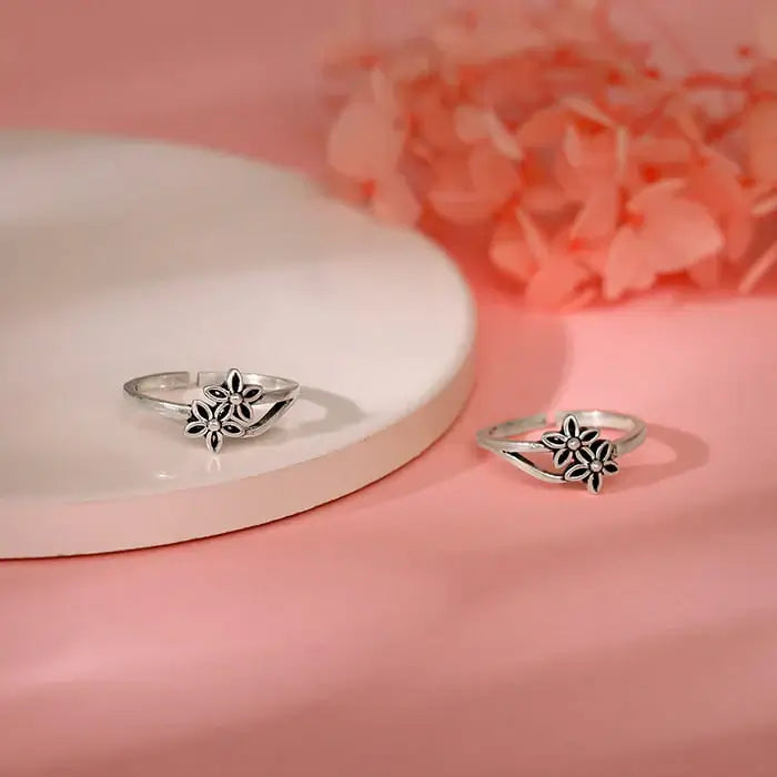 Oxidised Silver floral rings displayed on a pink background, showcasing vintage-style jewelry.