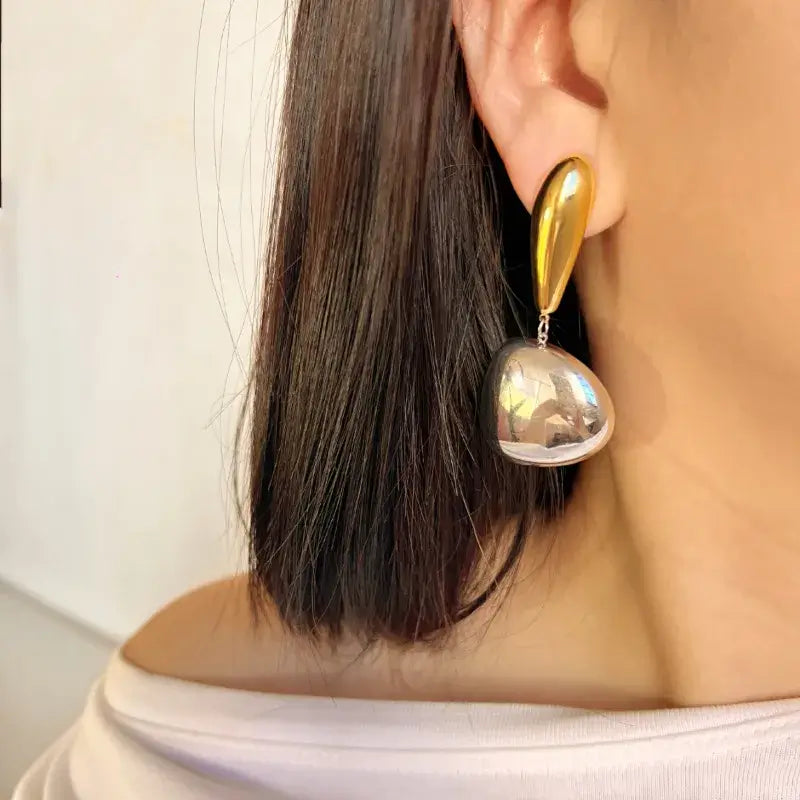 Geometric stainless steel drop earrings close-up showing gold plating
