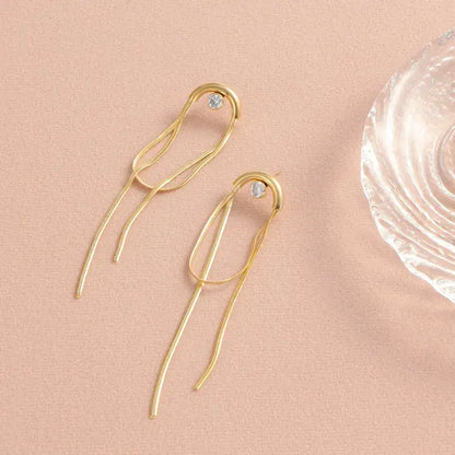 Woman wearing zircon tassel drop earrings with elegant outfit