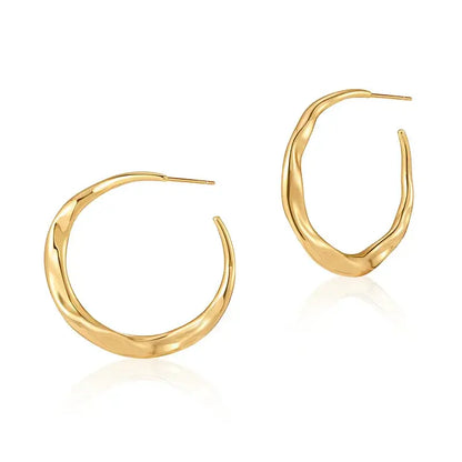 Close-up of irregular copper stud earrings showing sleek plated finish