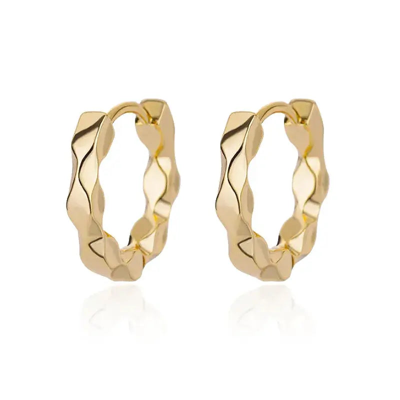 Simple gold-plated earrings displayed on luxury stand