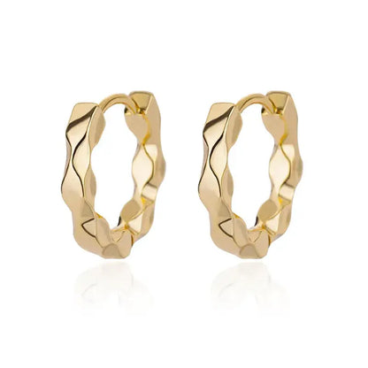 Simple gold-plated earrings displayed on luxury stand