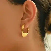 Close-up of C-shaped stainless steel stud earrings showing gold plating