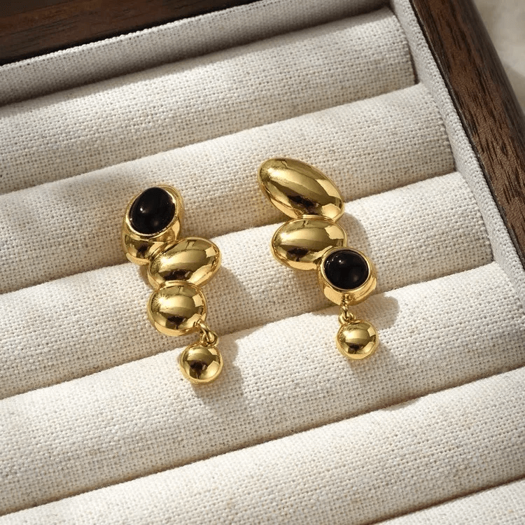 Geometric streetwear earrings in gold with black accents, showcasing bold shapes for urban style.