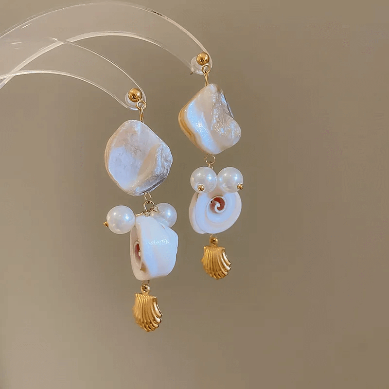 Summer shell tassel earrings featuring a geometric shell design and soft cloth tassels.