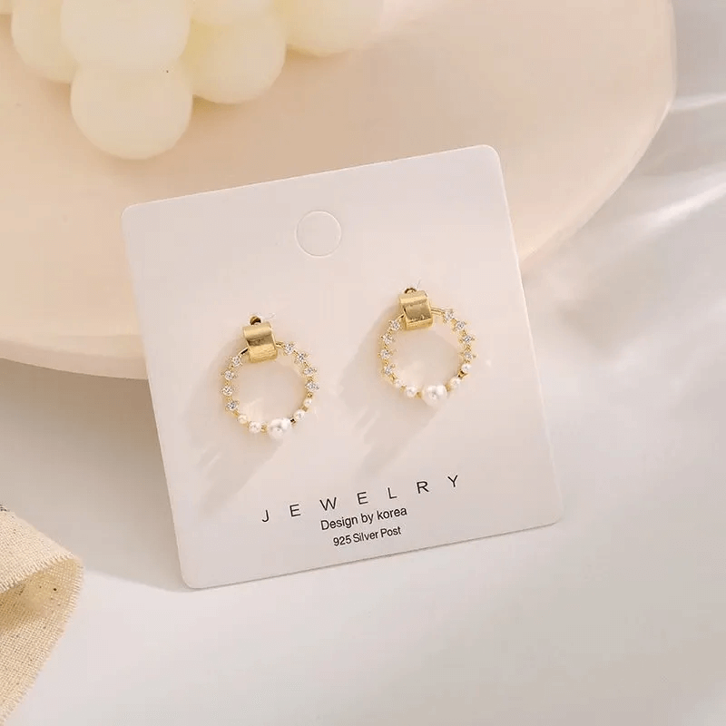 Pearl rhinestone shell earrings displayed on a jewelry card featuring gold and silver elements.