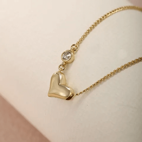 Heart shape gemstone necklace featuring a gold alloy chain and sparkling artificial gemstone accent.