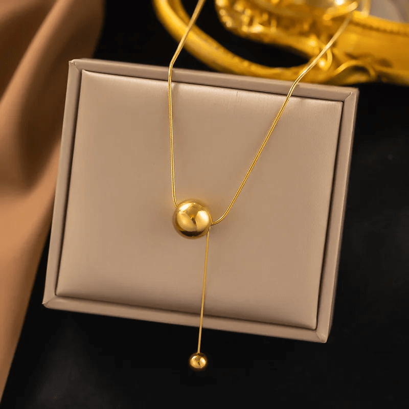 18K gold plated pendant necklace showcased on a jewelry box, featuring a sleek gold design with elegant round pendants.