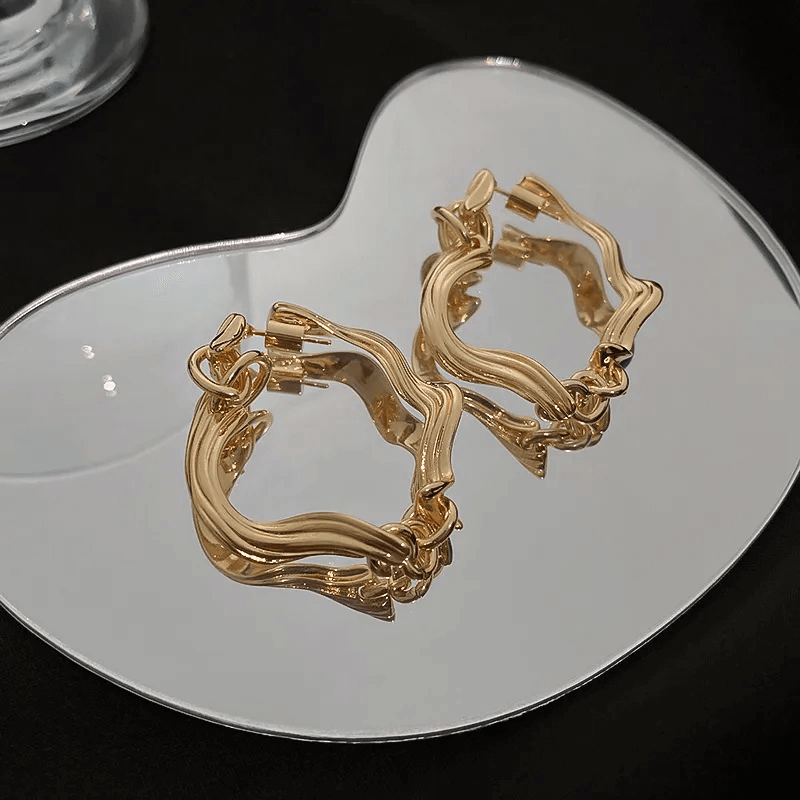 Elegant Earrings – Geometric Flower Design, Polished Finish displayed on a reflective surface.