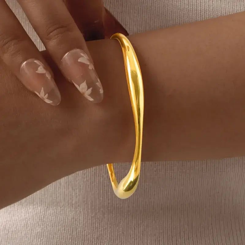 Woman wearing gold-plated classic bangle with elegant outfit