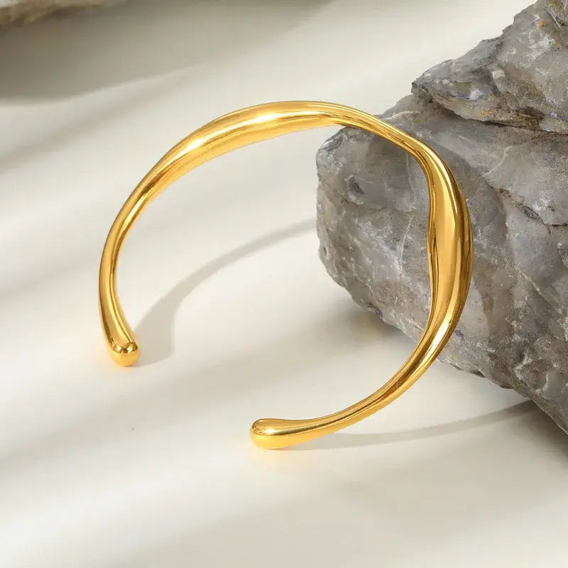 Close-up of gold-plated classic bangle showing smooth solid color finish