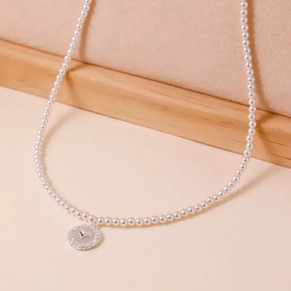 Freshwater pearl pendant necklace worn by model with layered jewelry