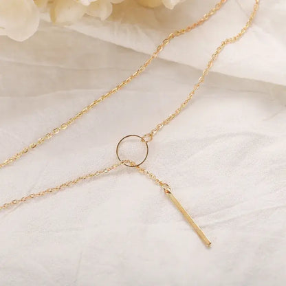Minimalist Y-shaped necklace worn by model with layered jewelry
