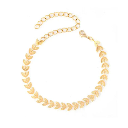 Woman wearing gold-plated leaf bracelet with elegant outfit