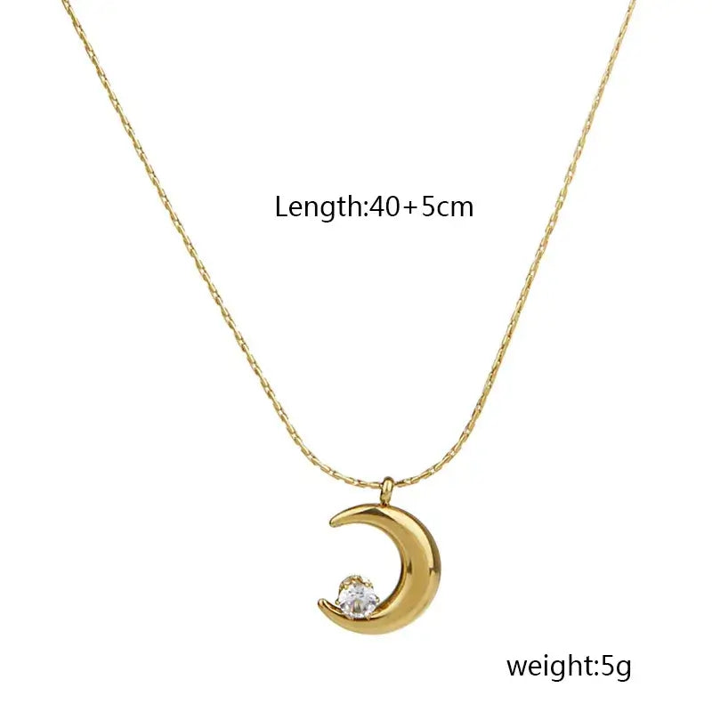 Gold moon pendant necklace displayed on jewelry stand