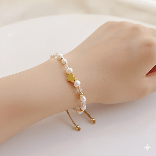 Star and heart pearl bracelet worn on a woman's wrist, featuring pearls and heart design.
