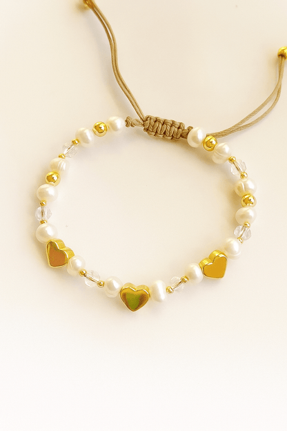 Woman wearing heart charm bracelet with stylish outfit