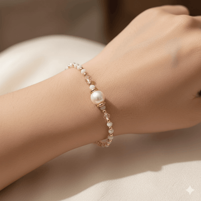 18K gold plated charm bracelet featuring pearls and soft clay charms, worn elegantly on a woman's wrist.