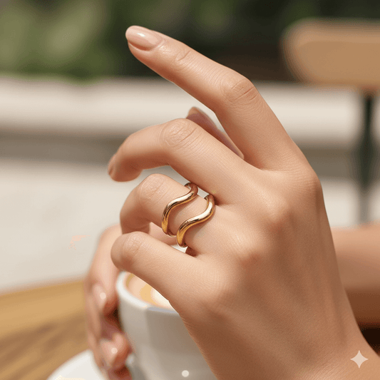 Gold plated geometric open ring worn on a hand with coffee cup, showcasing modern jewelry style.