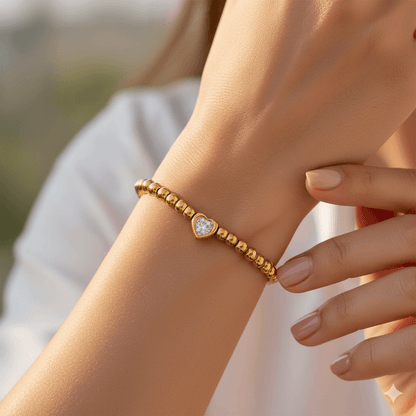 16K gold plated heart bracelet worn on a woman's wrist, showcasing elegant design and sparkling zircon inlay.