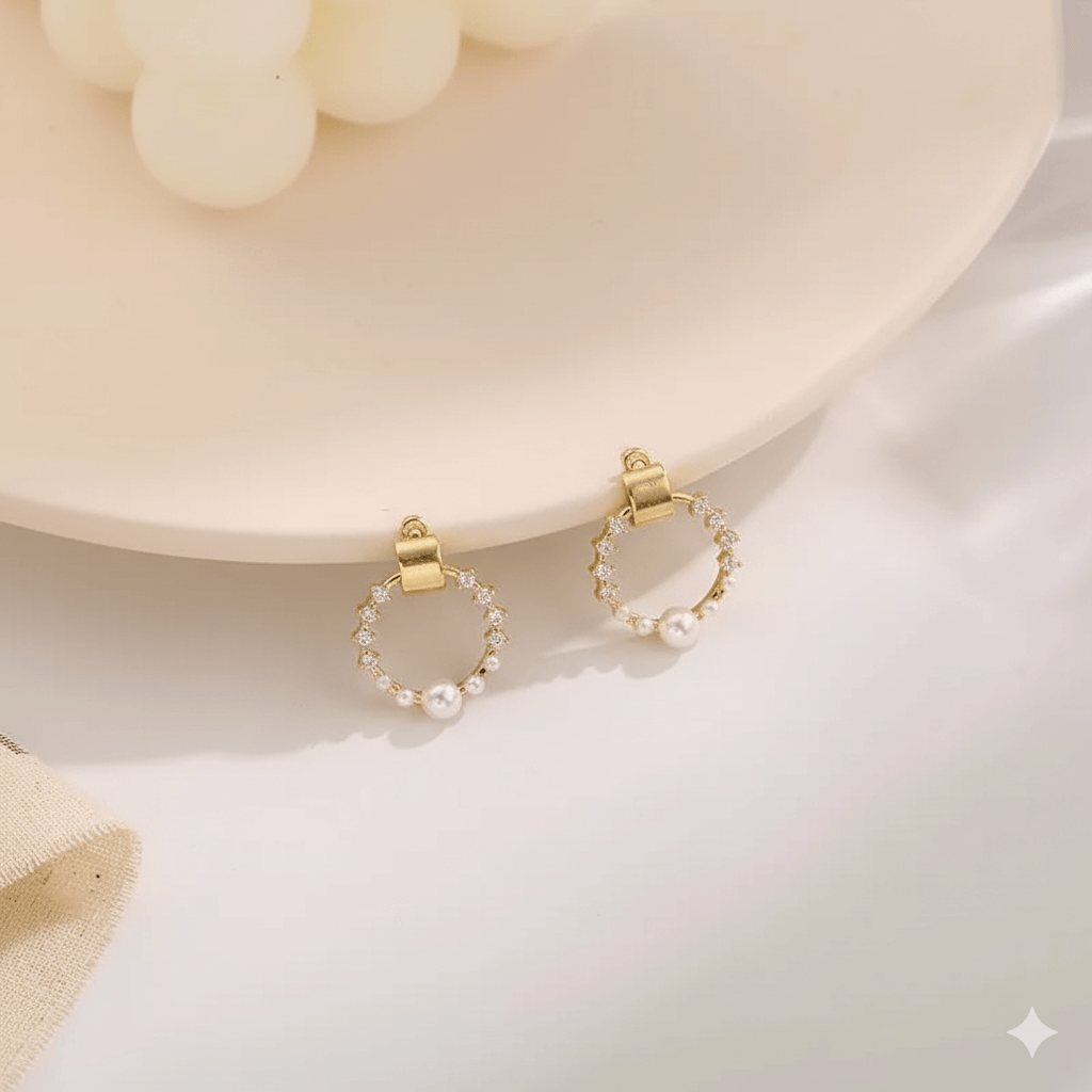 Elegant pearl rhinestone shell earrings displayed on a pink plate, showcasing their charming design and shine.