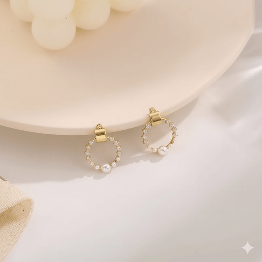 Elegant pearl rhinestone shell earrings displayed on a pink plate, showcasing their charming design and shine.