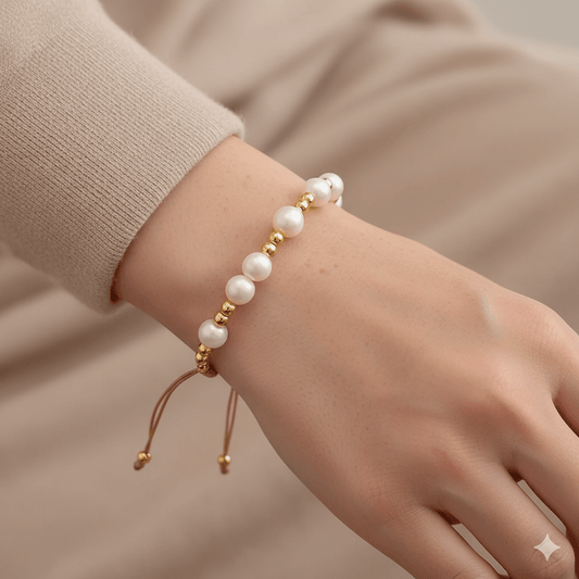 Trendy geometric bracelet for women with freshwater pearls and gold accents, worn on a hand.