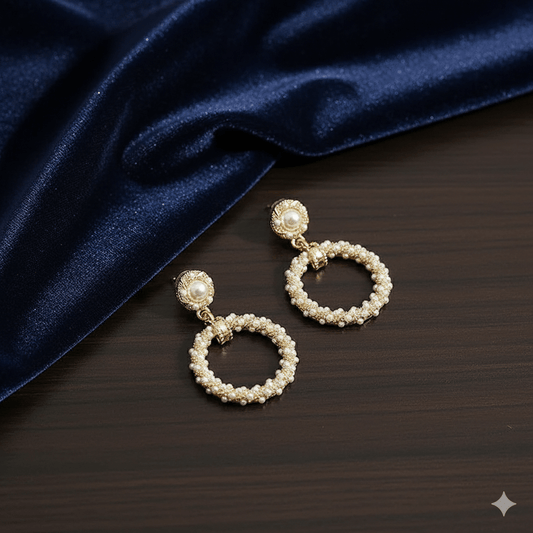 Flower butterfly bow earrings with pearls and rhinestones on a dark fabric background.
